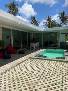 a house with a swimming pool on a patio at Bliss Villa Central Kuta in Kuta Lombok