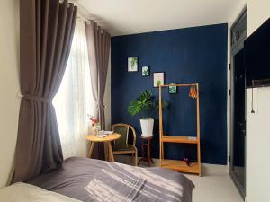 a bedroom with a blue wall with a bed and a table at Hello Dalat Hostel in Da Lat +13 photos