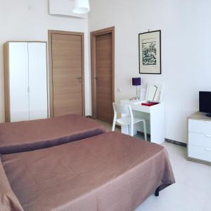 a bedroom with two beds and a desk and a table at B&B Sorgente 23 in Salerno