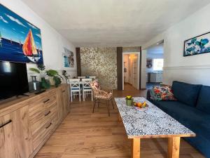 a living room with a blue couch and a table at Łagów apartament z plażą i pomostem in Łagów +45 photos