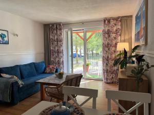 a living room with a blue couch and a table at Łagów apartament z plażą i pomostem in Łagów