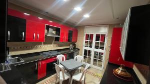 a kitchen with red cabinets and a table and chairs at Nador in Nador