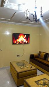 a living room with a fire on the wall at Nador in Nador +1 photo