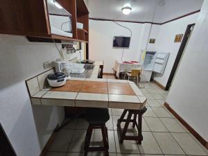 a kitchen with a counter and a table and chairs at Apartamento 4 Tec in Cartago