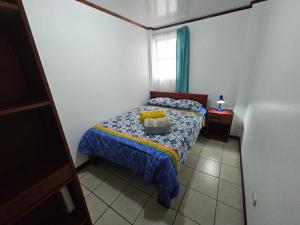 a small bedroom with a bed and a window at Apartamento 4 Tec in Cartago