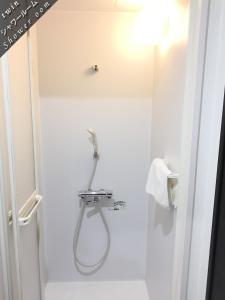 a shower with a hose in a white bathroom at Hotel Links Dobutsuenmae in Osaka +26 photos