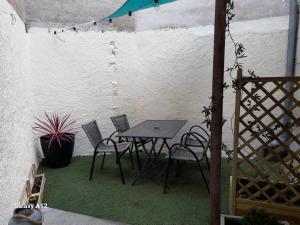 a patio with a table and chairs in a wall at Maison centre ville Bourgueil in Bourgueil +4 photos