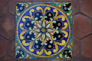 a blue tile with a flower pattern on a wall at Villa Salvatore in San Leone