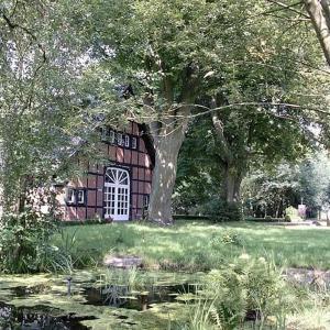 una pintura de una casa con un árbol y un estanque en Münsterland Cottage, en Lengerich