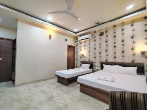a hotel room with two beds and azeb sidx sidx sidx sidx sidx at Hotel Holiday Palace in Sibsāgar