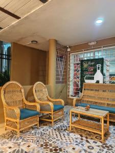 a patio with two chairs and a coffee table and a table at Hostal Nomadas in Santa Marta