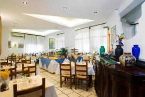 a restaurant with tables and chairs in a room at Hotel Berna in Eraclea Mare