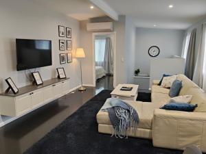 a living room with a couch and a flat screen tv at Carefree Comfort in Deception Bay