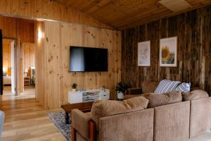 a living room with a couch and a flat screen tv at Sampsons Shack in Vivonne Bay