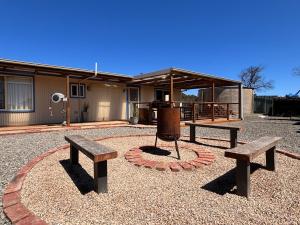 two benches sitting in a circle in front of a building at Sampsons Shack in Vivonne Bay