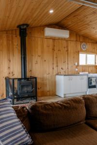 a living room with a fireplace and a couch at Sampsons Shack in Vivonne Bay
