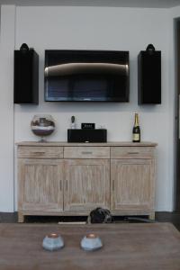a wooden entertainment center with a television on a wall at La Crème in Ostend
