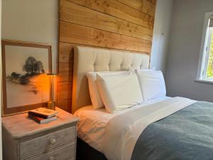 a bedroom with a bed and a table with a lamp at The Black Barn At Puketitiri in Puketitiri