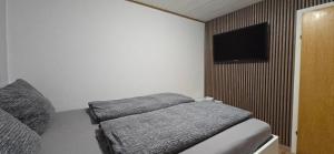 a bedroom with a bed and a flat screen tv at Ferienwohnung Nikolaus in Bernkastel-Kues