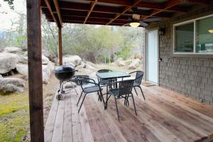 a patio with a grill and a table and chairs at The Hut at Deer Hollow in Three Rivers