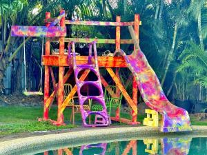 a playground with a slide next to a pool at Backpacker Bunks and Queen Pool Clifton Beach in Clifton Beach