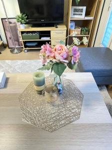 a vase of flowers on a table in a living room at Yoshimi Stay Kawaguchi in Kawaguchi