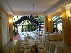 ein langer Festsaal mit weißen Tischen und Stühlen in der Unterkunft Okulski Grand Rozewie Pokoje i Apartamenty in Jastrzębia Góra