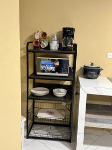 a microwave on a shelf in a kitchen at Alojamiento Golfito in Golfito +12 photos