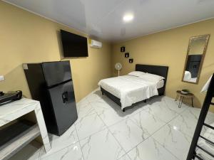 a bedroom with a bed and a large white marble floor at Alojamiento Golfito in Golfito