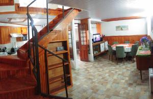 a living room with a staircase and a dining room at Cabaña cerca del TEC in Cartago