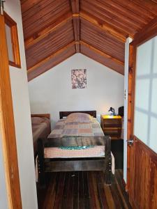 a bedroom with a bed in a room with wooden ceilings at Cabaña cerca del TEC in Cartago