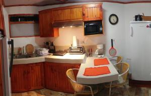 a kitchen with a table with chairs and a stove at Cabaña cerca del TEC in Cartago +6 photos