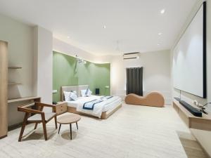a bedroom with a bed and a flat screen tv at Hotel VD Rooms Althan in Surat