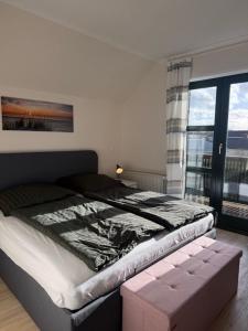 a bedroom with a bed and a large window at Haakestrasse 1j in Dahme