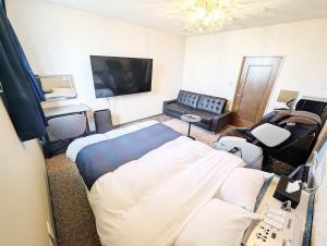 a hospital room with a bed and a couch at セルフプラスホテル銚子無人ホテル in Choshi