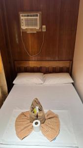 a towel and a cup on a bed with a fan at Port Barton - Paradiso Azul Campsite Beachfront with Internet in San Vicente