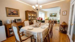a dining room with a table and chairs and a kitchen at Strathaird Bed and Breakfast in Niagara Falls