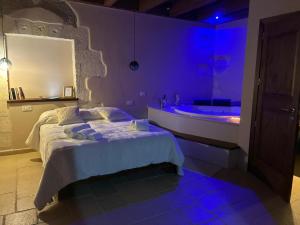 a bedroom with a bed and a tub with purple lighting at Il Lentisco in Codrongianos