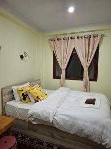 a bedroom with two beds and a window at Mountain View Homestay in Tānsen