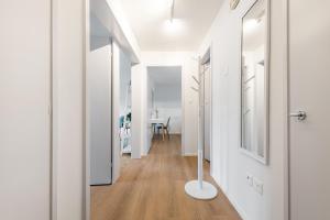 a hallway with white walls and wooden floors and a white door at COZY 1 !Gratis Parken, Free Parking! in Weinfelden