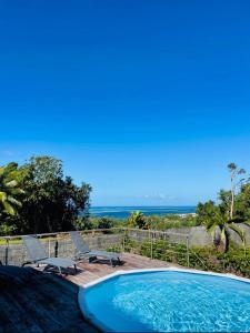 ein Swimmingpool mit Blick auf das Meer in der Unterkunft Rainforest Valley in Mataiea
