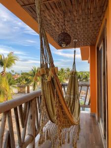 a hammock on a balcony with a view of the ocean at Casa Ilhéus Pousada in Ilhéus