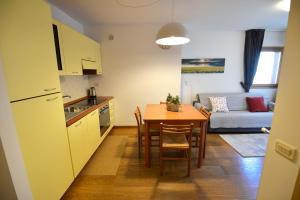 a kitchen and a dining room with a table and a couch at Eleonora 4A in Temù
