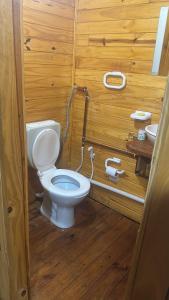 a bathroom with a toilet in a wooden room at La cabaña de Noe in San Clemente del Tuyú