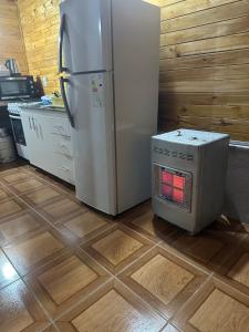 a kitchen with a refrigerator and a microwave at La cabaña de Noe in San Clemente del Tuyú
