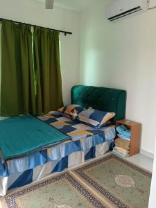 a bedroom with a bed with a green head board at All Rushd Private Pool Homestay in Sungai Besar