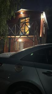 a car parked in front of a house at night at La cabaña de Noe in San Clemente del Tuyú
