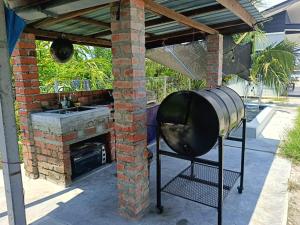 a kitchen with a grill and a smoker in a patio at All Rushd Private Pool Homestay in Sungai Besar