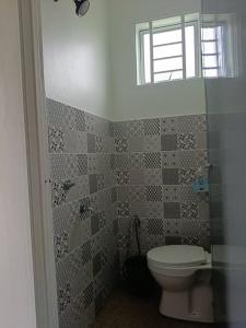 a bathroom with a toilet and a window at All Rushd Private Pool Homestay in Sungai Besar +21 photos