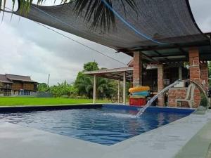 a swimming pool with a water fountain at All Rushd Private Pool Homestay in Sungai Besar